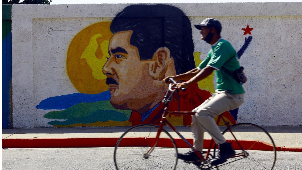 Un hombre pasa junto a un mural del presidente venezolano, Nicolás Maduro.