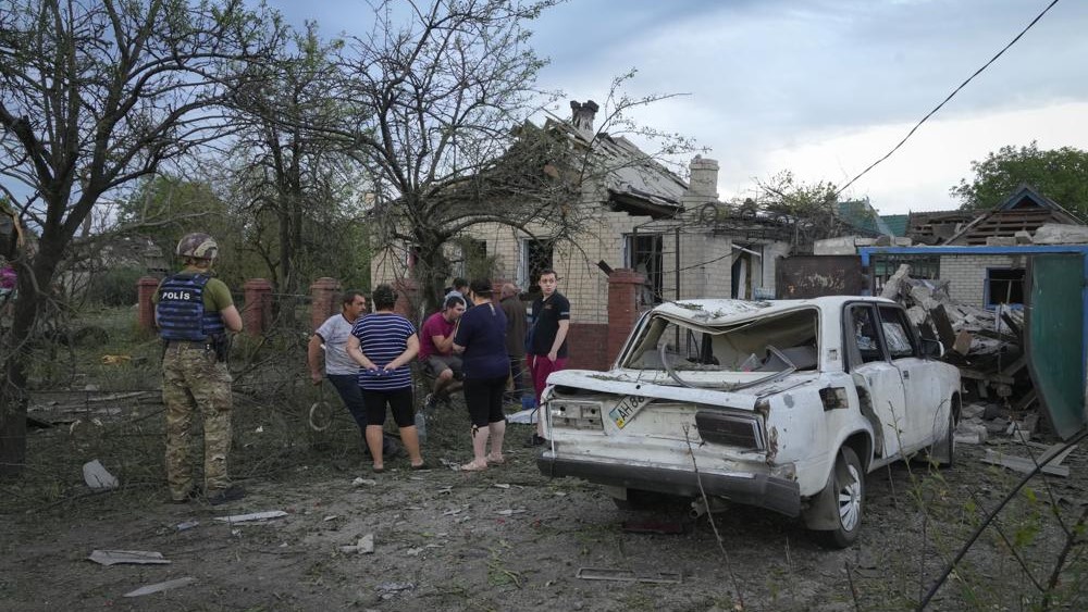 Residentes se reúnen cerca de casas dañadas por un ataque con cohetes rusos en Pokrovsk, Donetsk, Ucrania, 15 de junio.