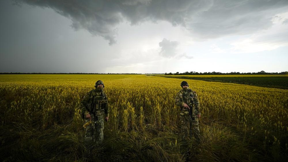 Soldados rusos vigilan en un campo de trigo mientras periodistas extranjeros trabajan en Zaporizhzhia, bajo control militar ruso, en el sureste de Ucrania, el 14 de junio de 2022.