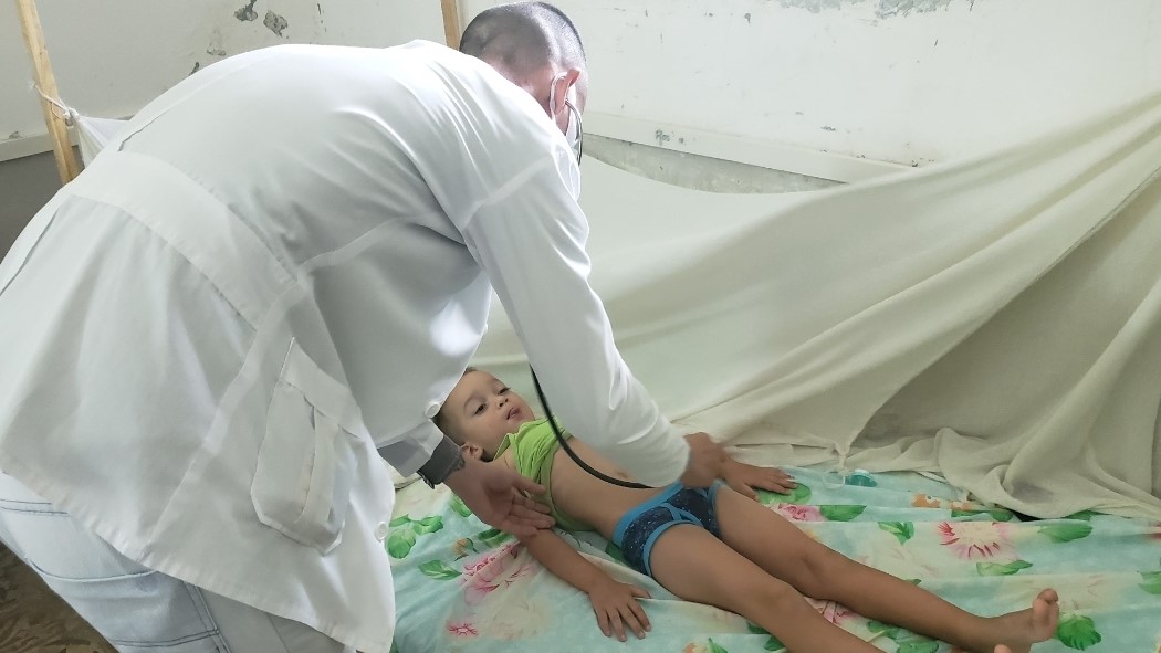 Un médico atiende a un niño con síntomas de dengue.