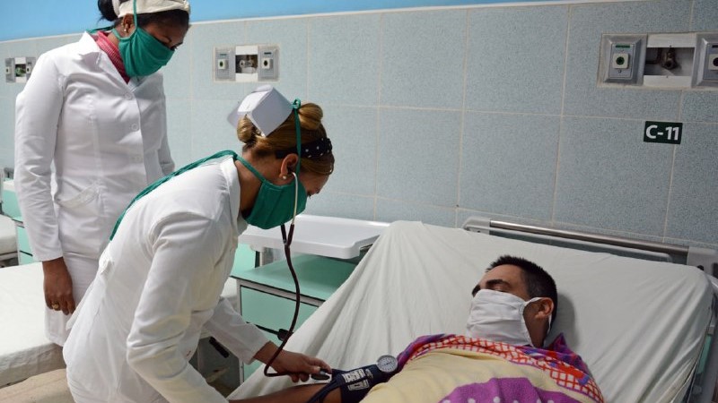 Dos enfermeras atienden a un paciente ingresado en un hospital de Cuba.