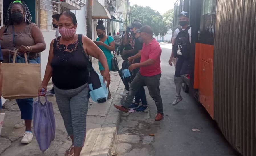 Cubanos bajando de un ómnibus en La Habana.