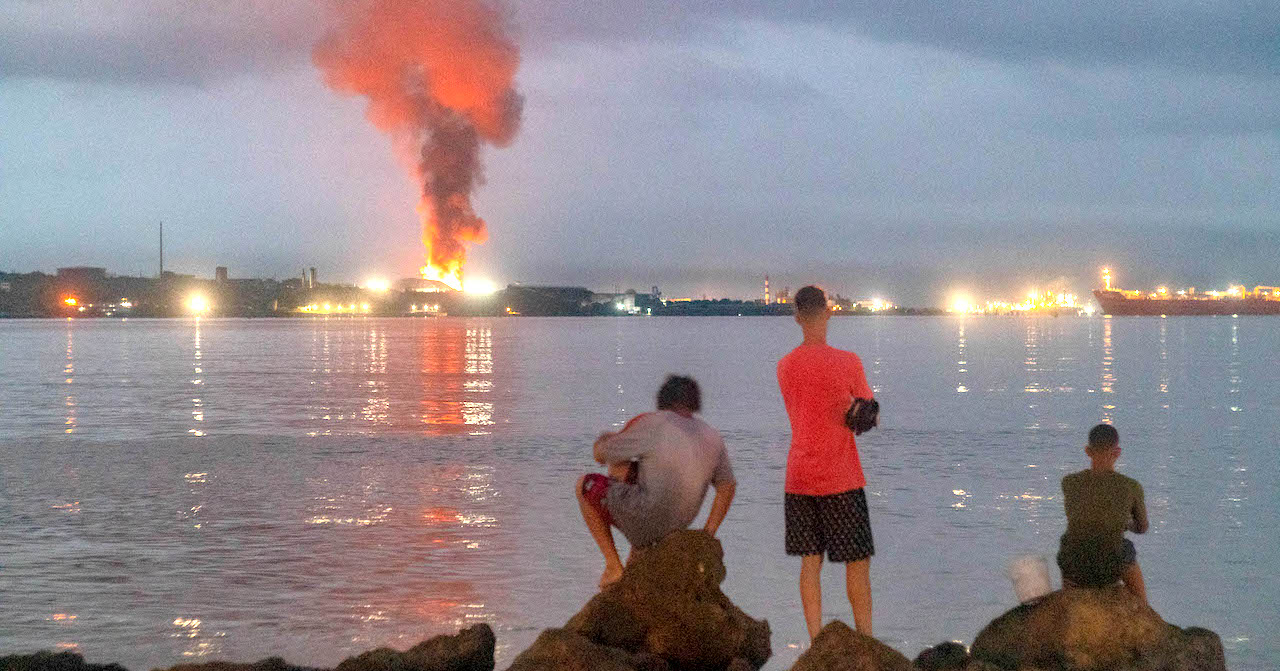 Matanceros observan el incendio en la base de supertanqueros.