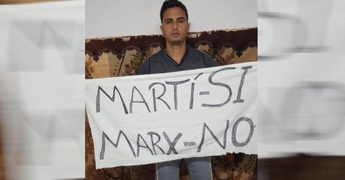 El joven cubano Yuri García con el cartel que salió el 15N.