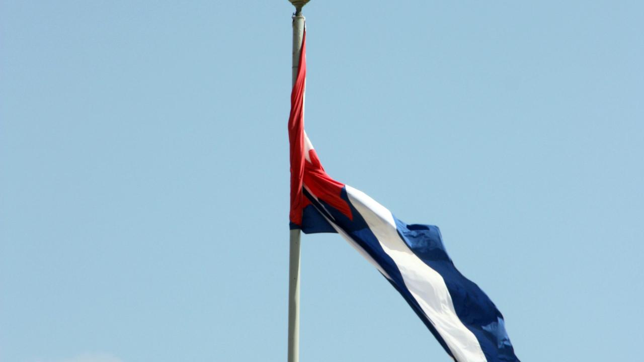 Una bandera cubana enrollada en su asta.
