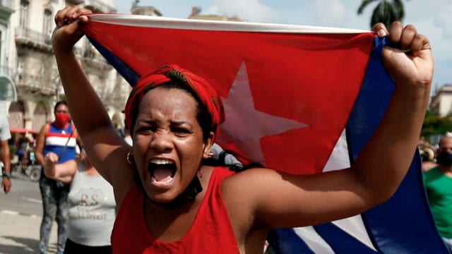 Una mujer protesta en La Habana con una bandera cubana.
