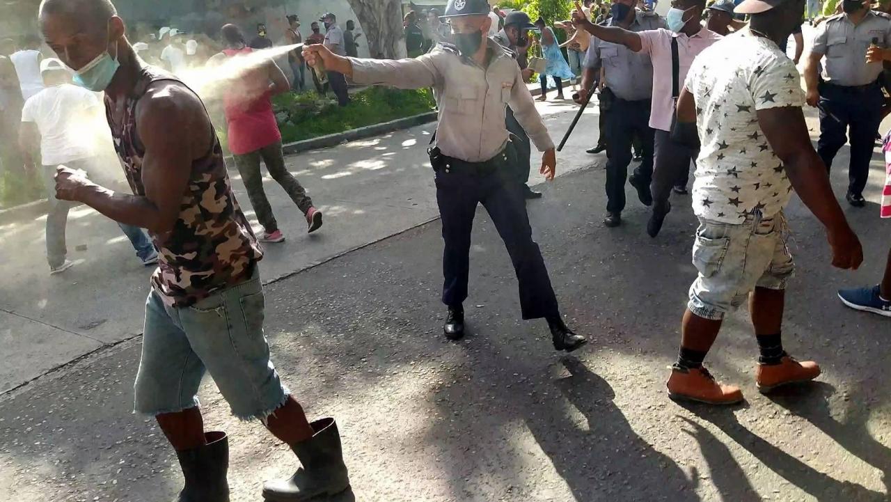 Policías usando gases contra los manifestantes el 11J en Cuba.