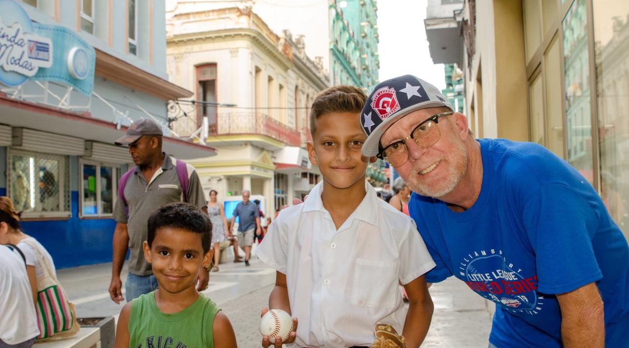 El fotógrafo estadounidense Parsons con niños cubanos a los que ha regalado guantes de béisbol.