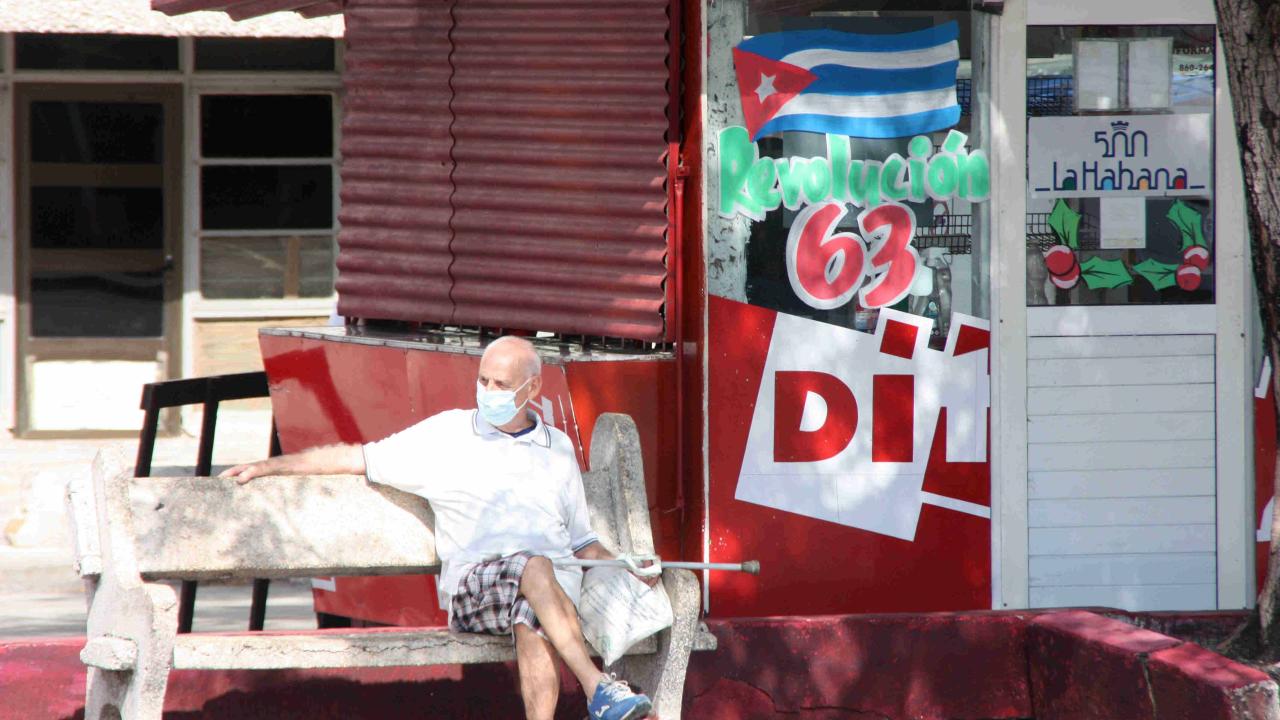 An elderly man in Havana in front of a closed cafeteria.