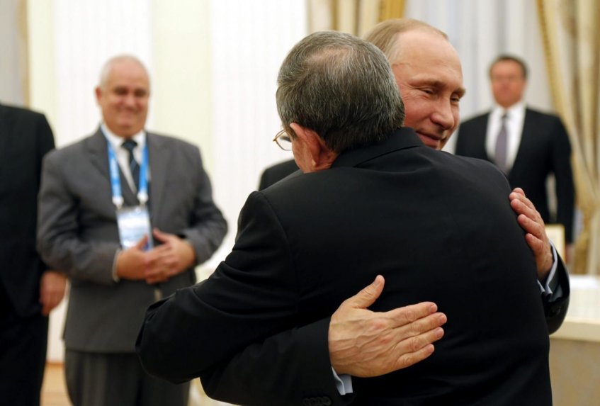 De espaldas, Raúl Castro, abrazado por Vladimir Putin.