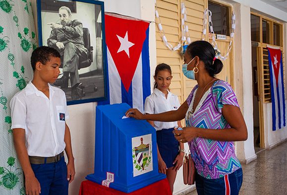 Encima de la urna electoral, la imagen de Fidel Castro.