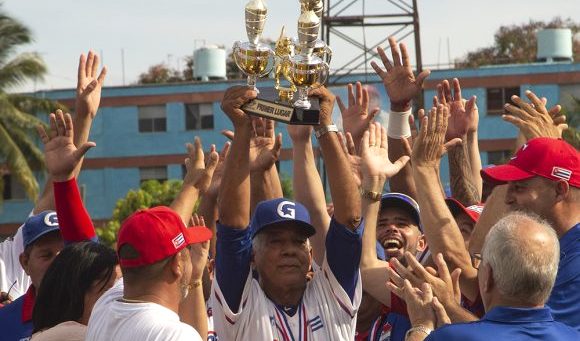 El manager Carlos Martí (c) alza el trofeo de la Serie Nacional de Béisbol junto a los Alazanes de Granma.