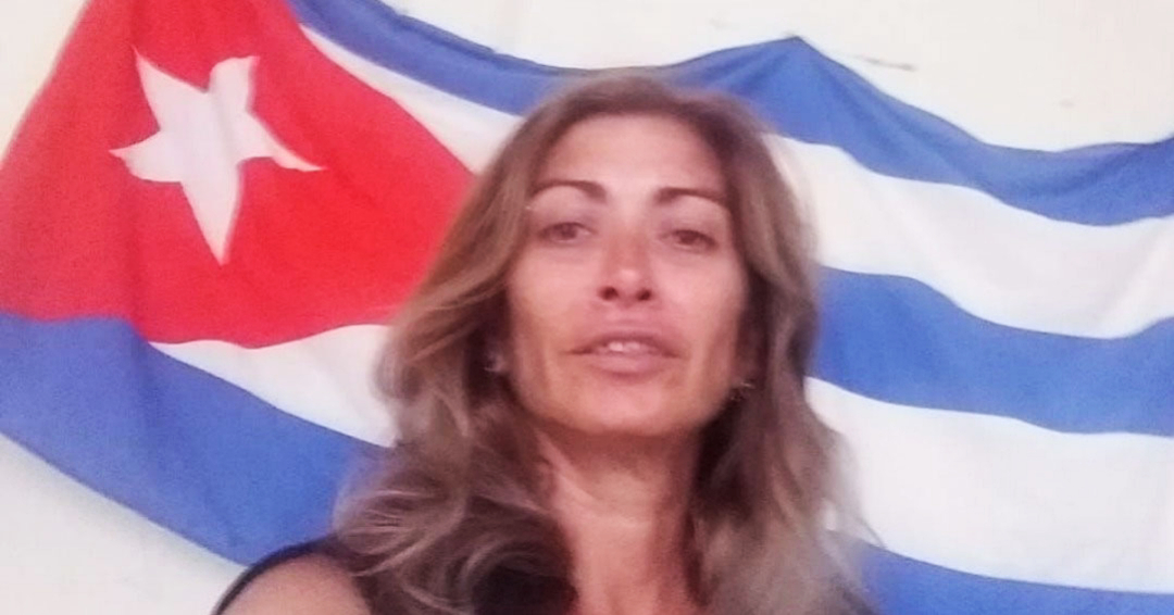 La activista Aniette González junto a la bandera cubana.
