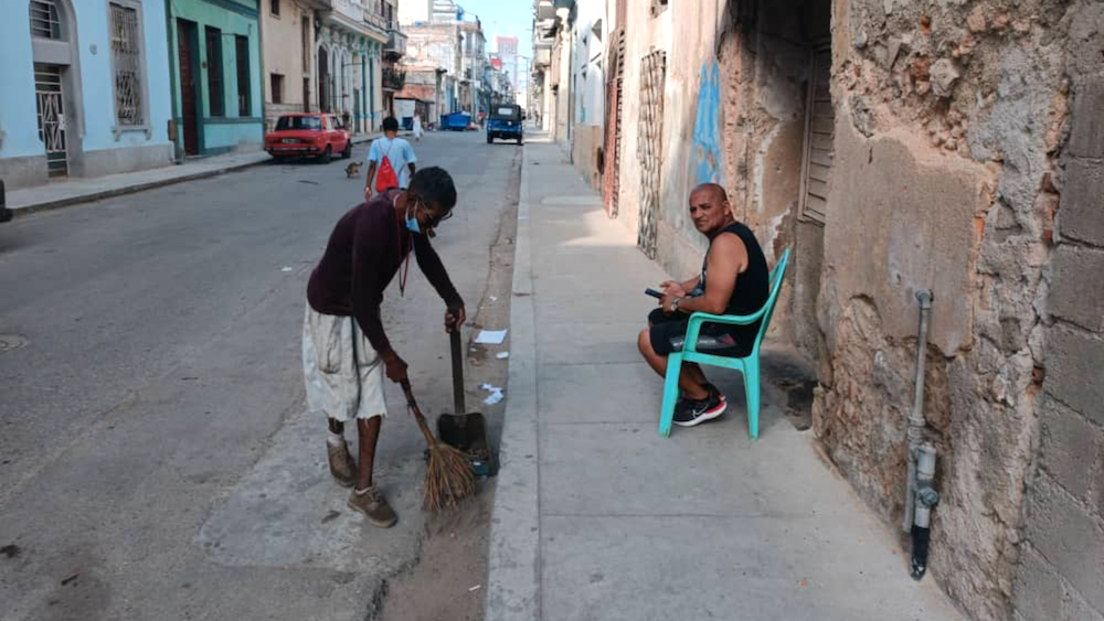 Un hombre barre la calle en La Habana.