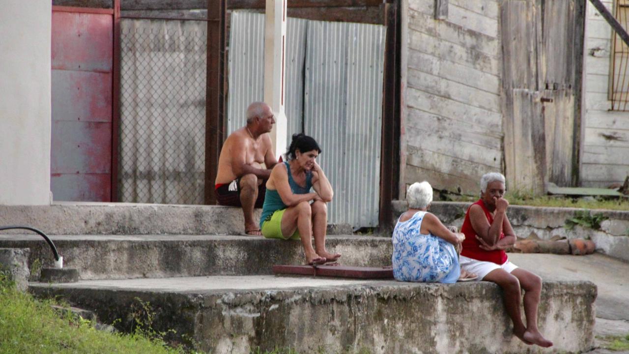 Cubanos en el frente de sus viviendas.