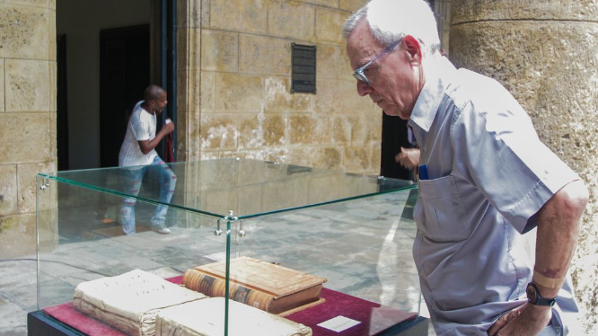 El fallecido historiador Eusebio Leal mira las actas capitulares del ayuntamiento de La Habana.