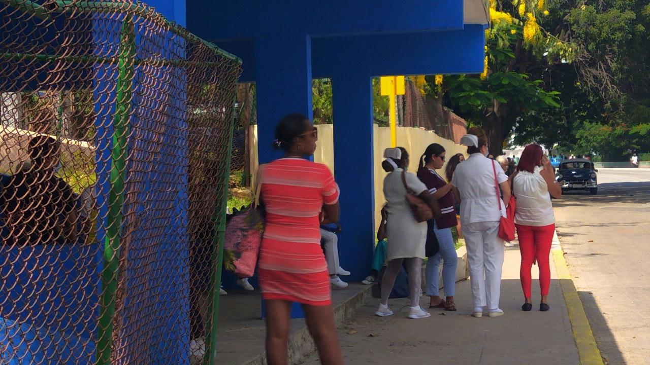 Mujeres en una parada de guaguas en Cuba.