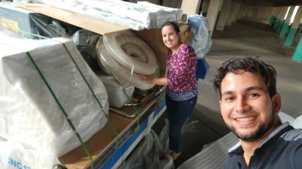 El ingeniero y empresario privado cubano Idián Chávez y su esposa Ana desempacan equipos industriales para su fábrica de papel higiénico en La Habana.
