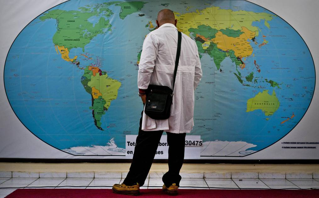 Un médico cubano ante un mapa del mundo.