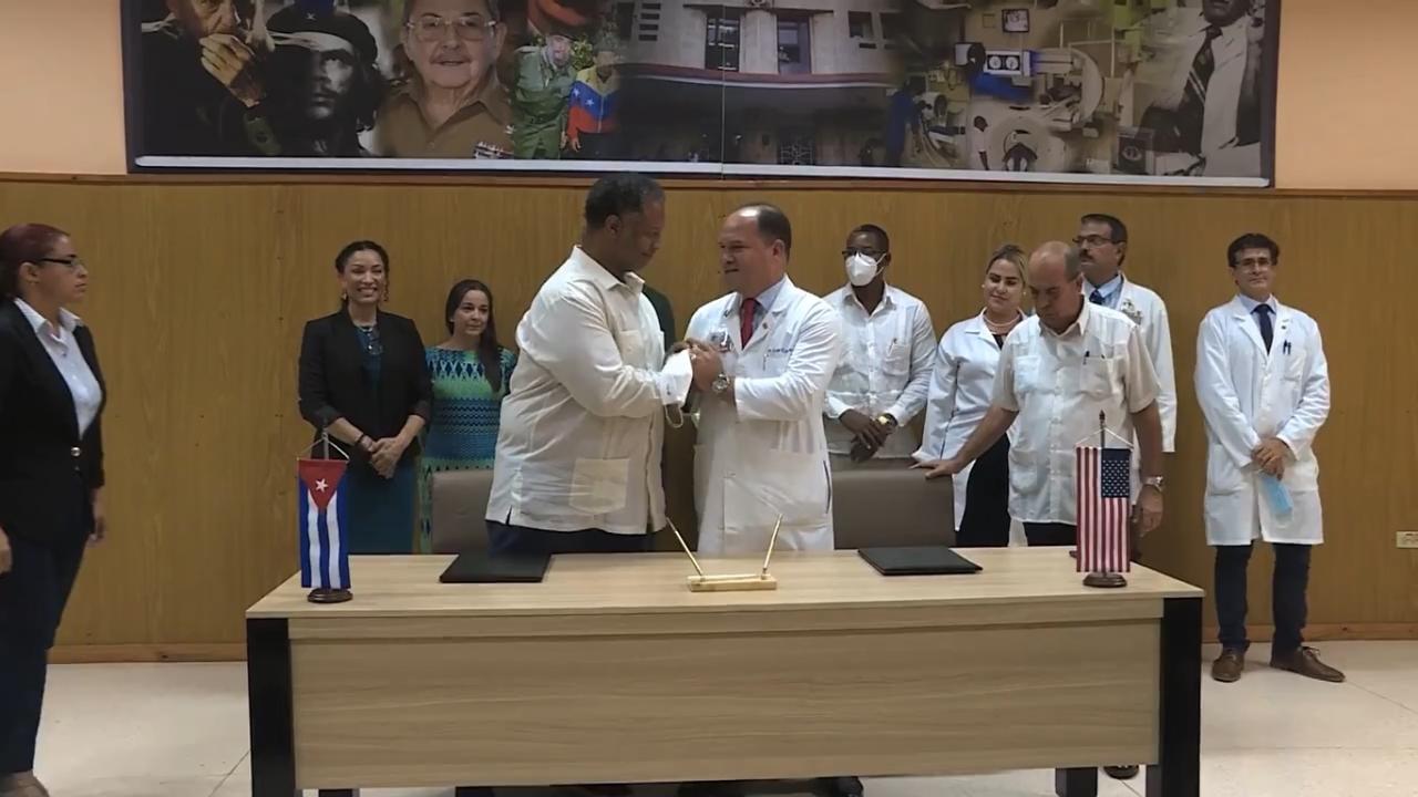 Funcionarios cubanos y científicos de EEUU firman el acuerdo para colaborar en investigaciones sobre el cáncer. Captura de pantalla.