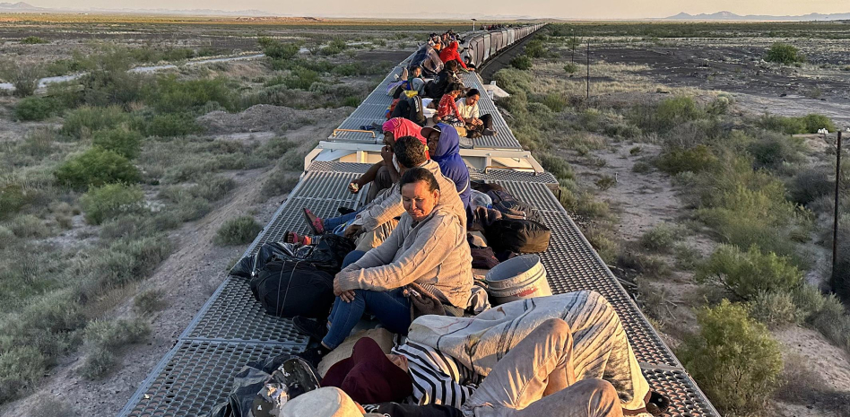  Un grupo de migrantes viaja sobre el tren conocido como "La Bestia".