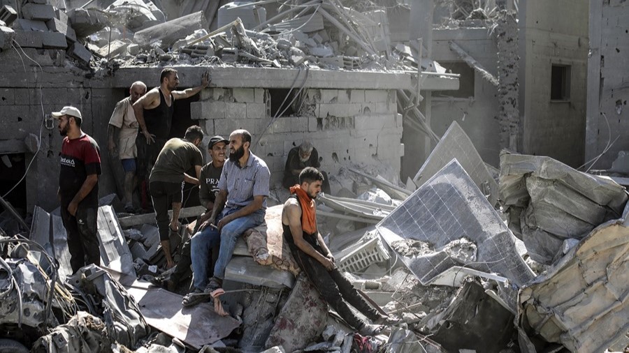 Ciudadanos palestinos sobre las ruinas de edificios de Gaza. 