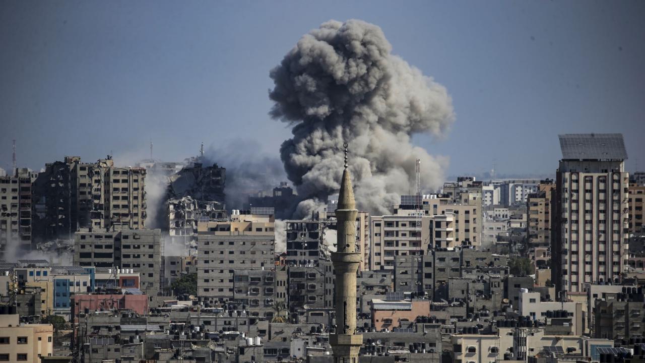 Una columna de humo se eleva entre los edificios de Gaza tras los ataques israelíes, este domingo.