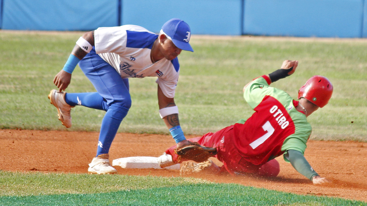 Un jugaro de Industriales y otro de Las Tunas, equipos que se enfrentarán en el partido inicial.