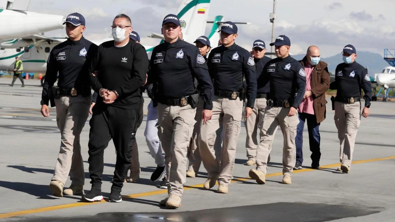 Agentes de Interpol conducen a antiguos integrantes de las FARC extraditados a EEUU en Bogotá, 2022.