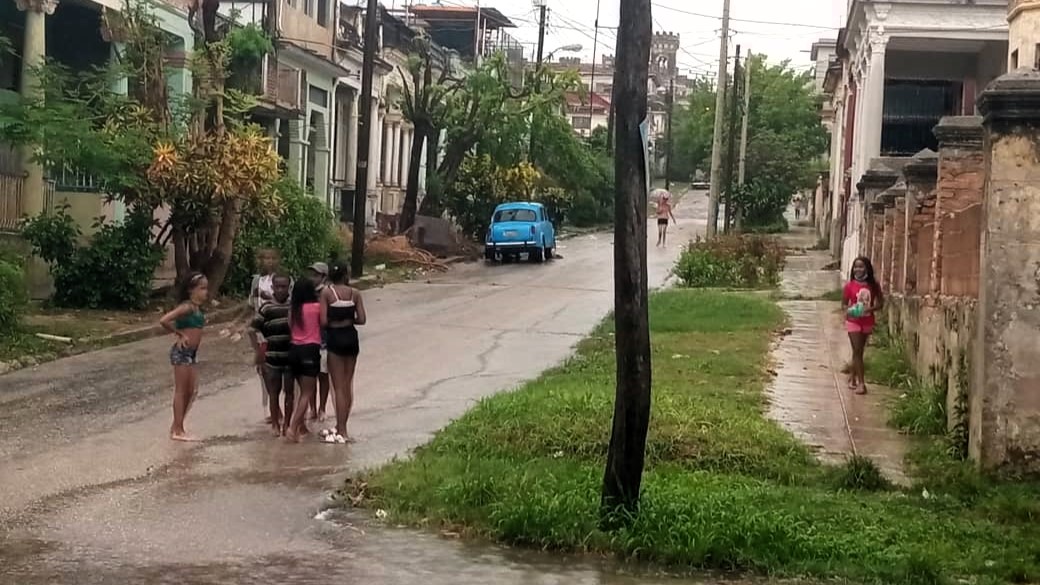 Niños bajo un aguacero en La Habana.