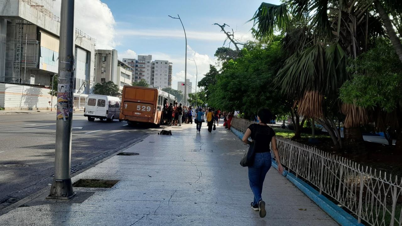 Personas intentando subir a una guagua en Cuba.