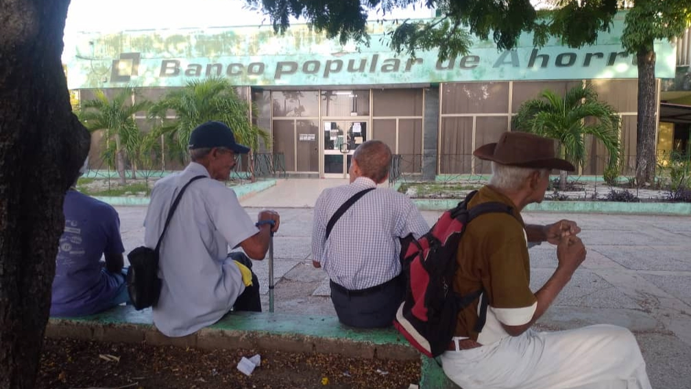 Ancianos hacen cola desde el amanecer para cobrar sus pensiones en un banco, en Santiago de Cuba.