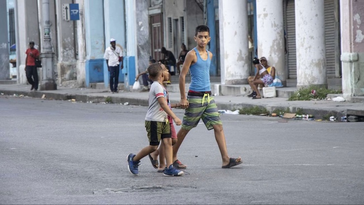 Niños caminando por una avenida habanera.