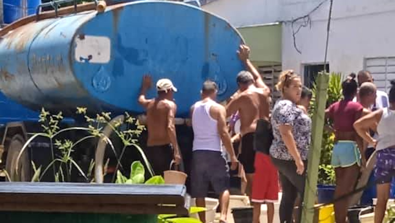 Vecinos de Caibarién recogiendo agua de una pipa.