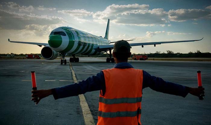 Un avión recibe orientaciones en la pista de aterrizaje.