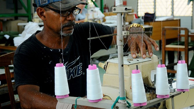 Un trabajador de Confecciones Trébol ante una máquina obsoleta.