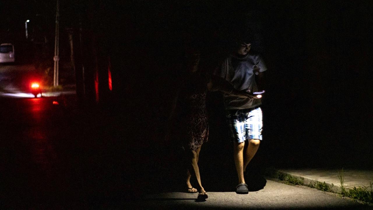 Una pareja camina por una calle en medio del apagón generalizado de Cuba.