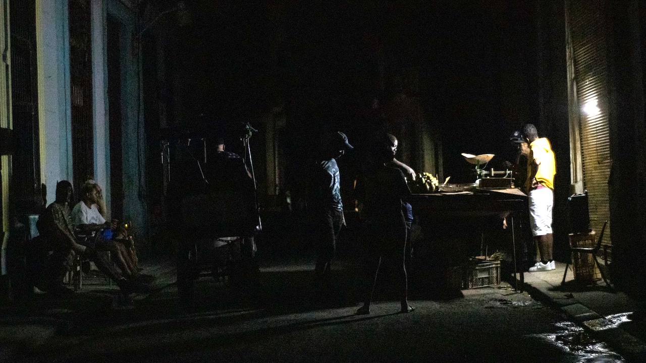 A street vendor selling produce in Havana in the middle of a blackout.