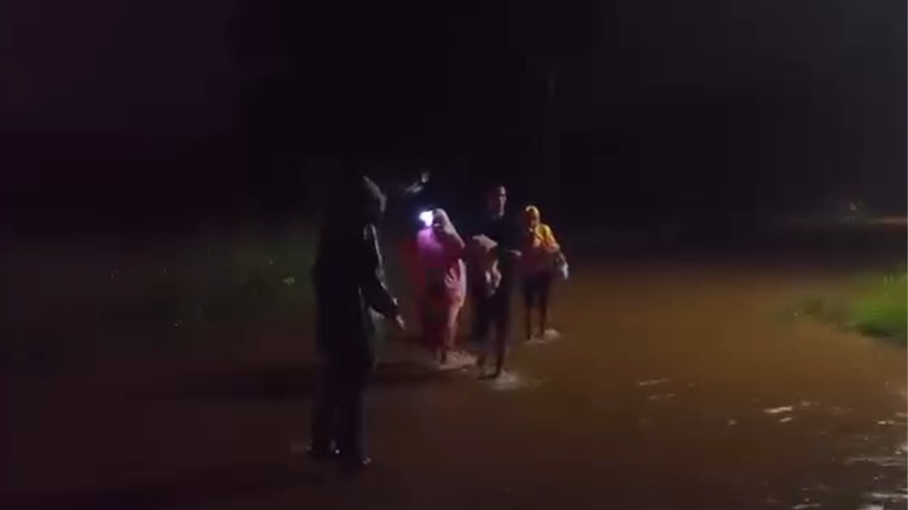 Personas caminando por una calle inundada en Moa.