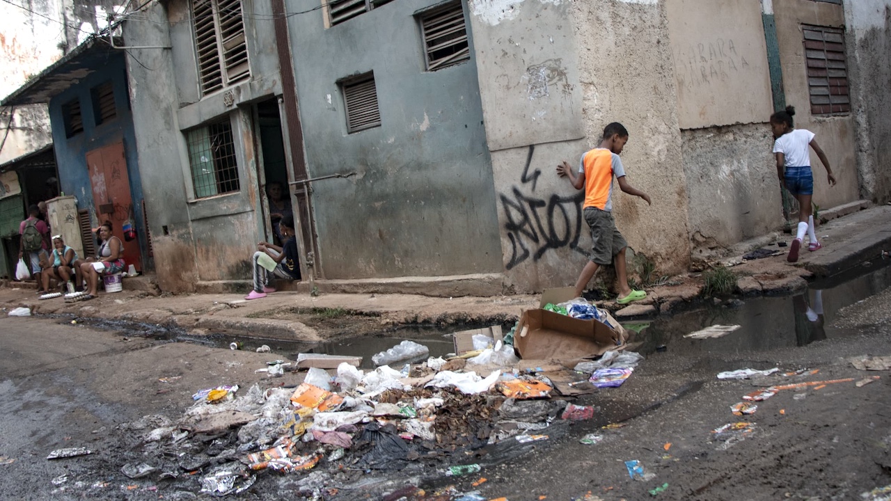 Children in a corner strewn with garbage in Havana.