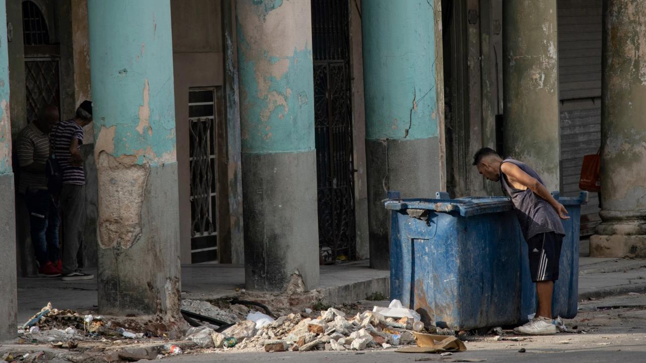 Un hombre revisa la basura en La Habana