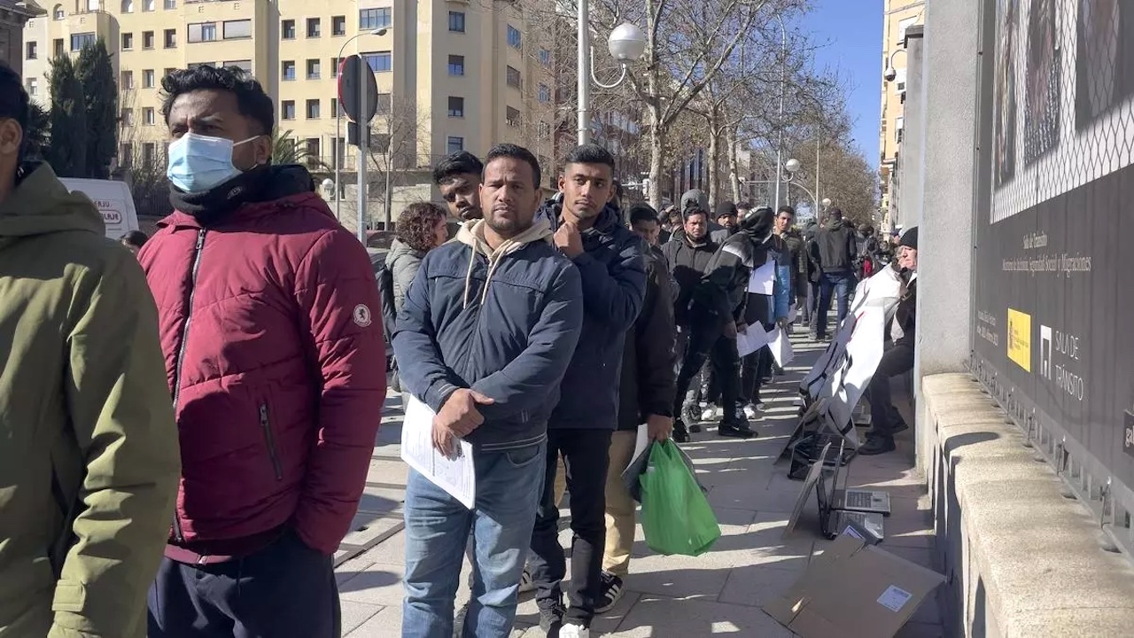 Emigrantes haciendo cola ante una oficina del Gobierno español.