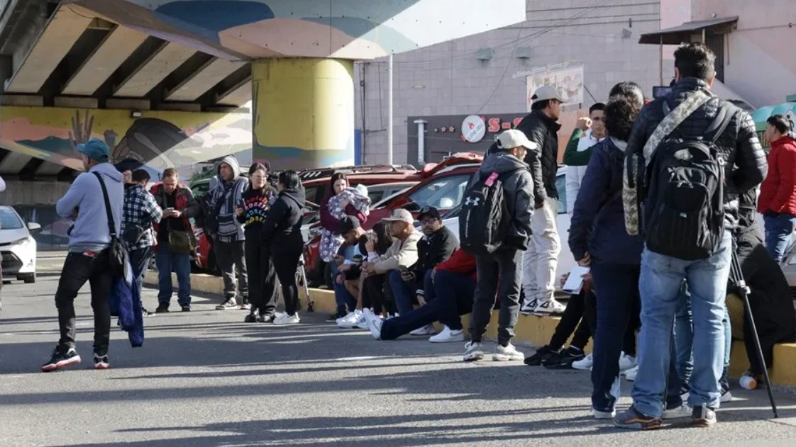 Migrantes permanecen varados, el 20 de enero de 2025, en el puerto fronterizo de El Chaparral, en Tijuana (México). 