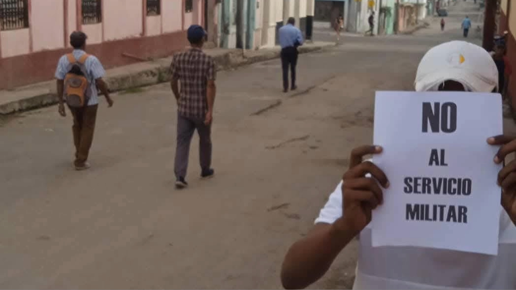 Un cubano con un cartel de rechazo al Servicio Militar Obligatorio.