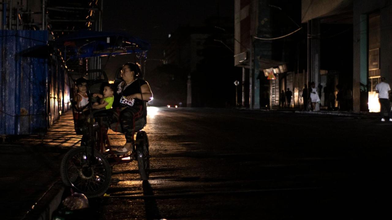 Una madre y sus hijos en un bicitaxi en medio del apagón de marzo en La Habana.