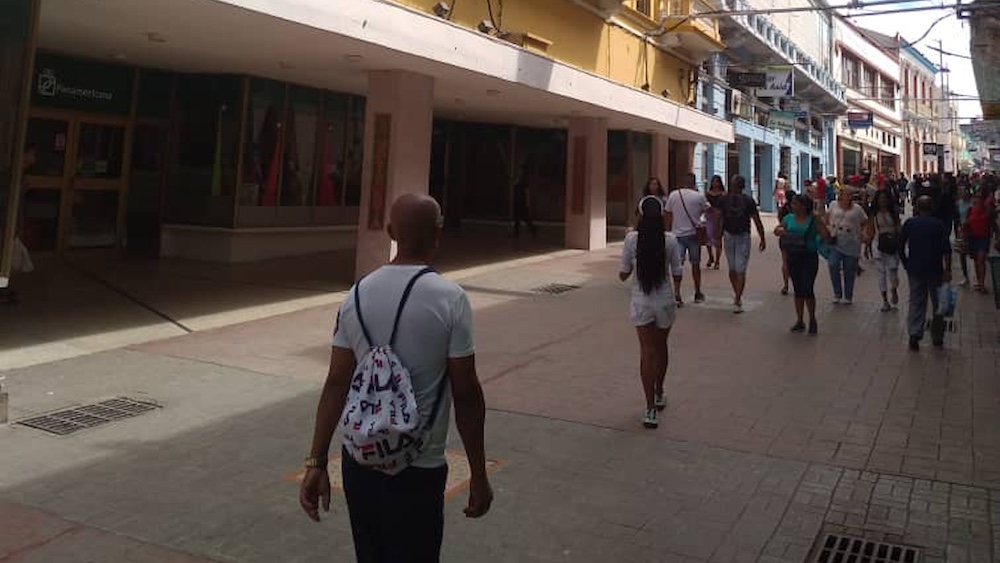 Santiagueros pasando ante La California (a la izq.), la recién abierta tienda en dólares de Santiago de Cuba.