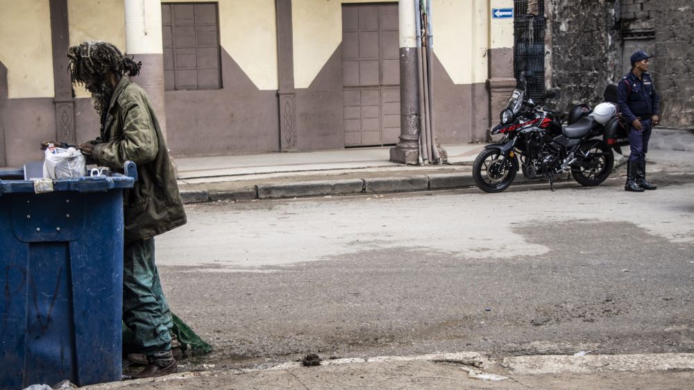 Un hombre hurgando en la basura en Cuba.