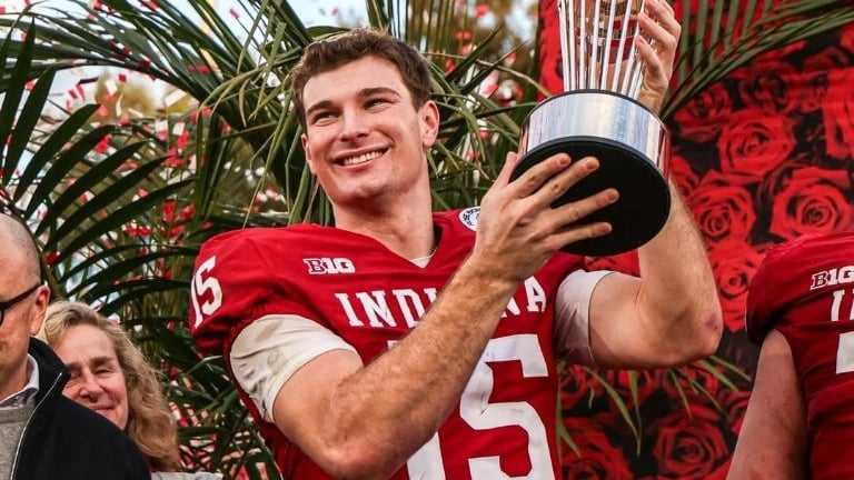 Fernando Mendoza alza el trofeo del fútbol americano universitario.