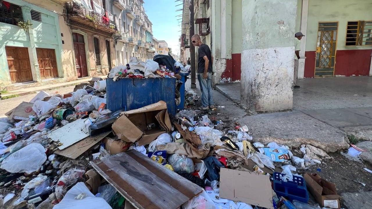 Un hombre mira un basurero en La Habana.