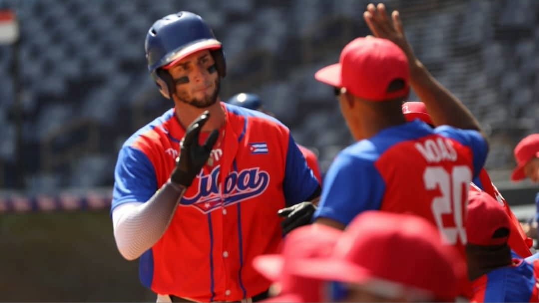 Peloteros cubanos celebran una anotación frente a Nicaragua.